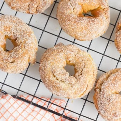 Air fryer donuts on a cooling rack next to a checkered napkin