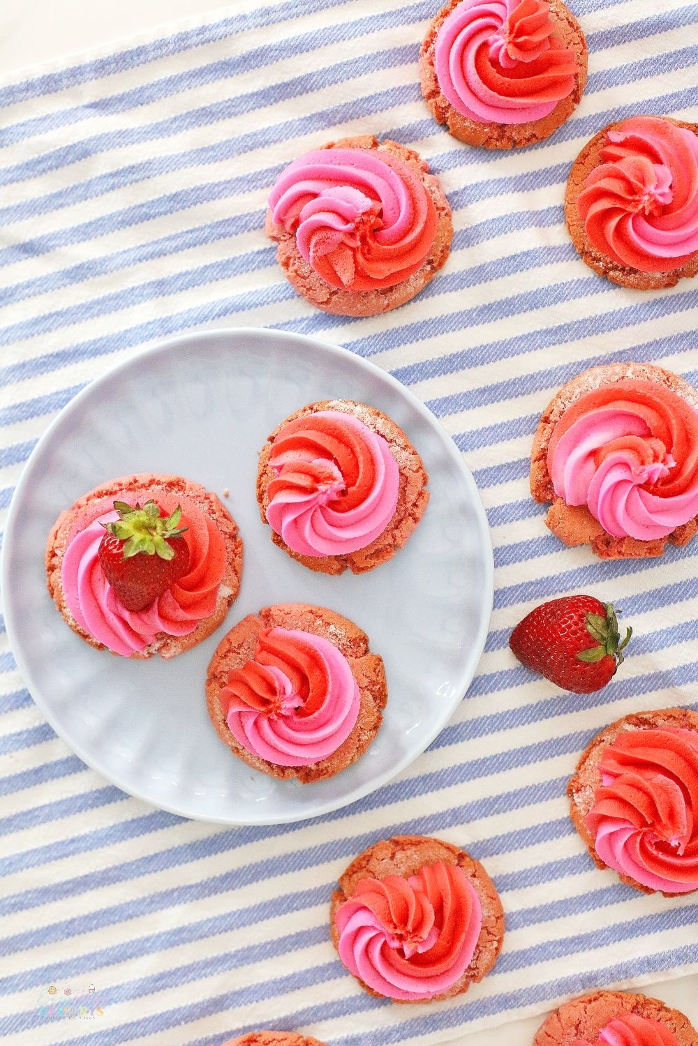 Image of strawberry and cream cookies decorated with fresh strawberries, on a kitchen napkin