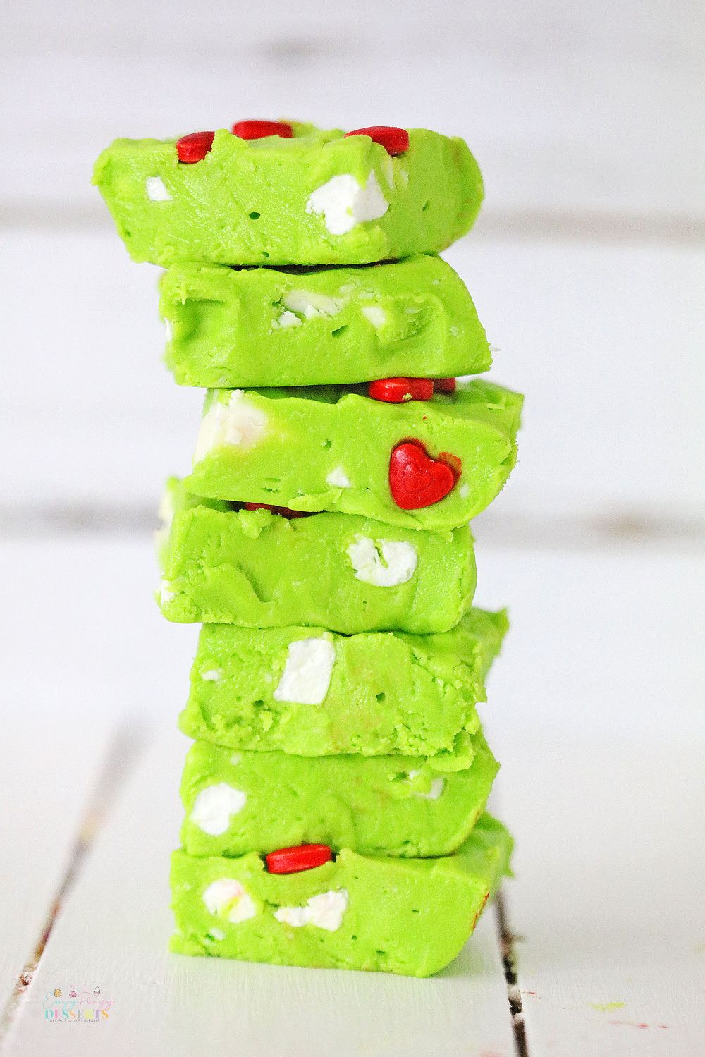 Slices of Grinch fudge displayed in a stack on a wooden table