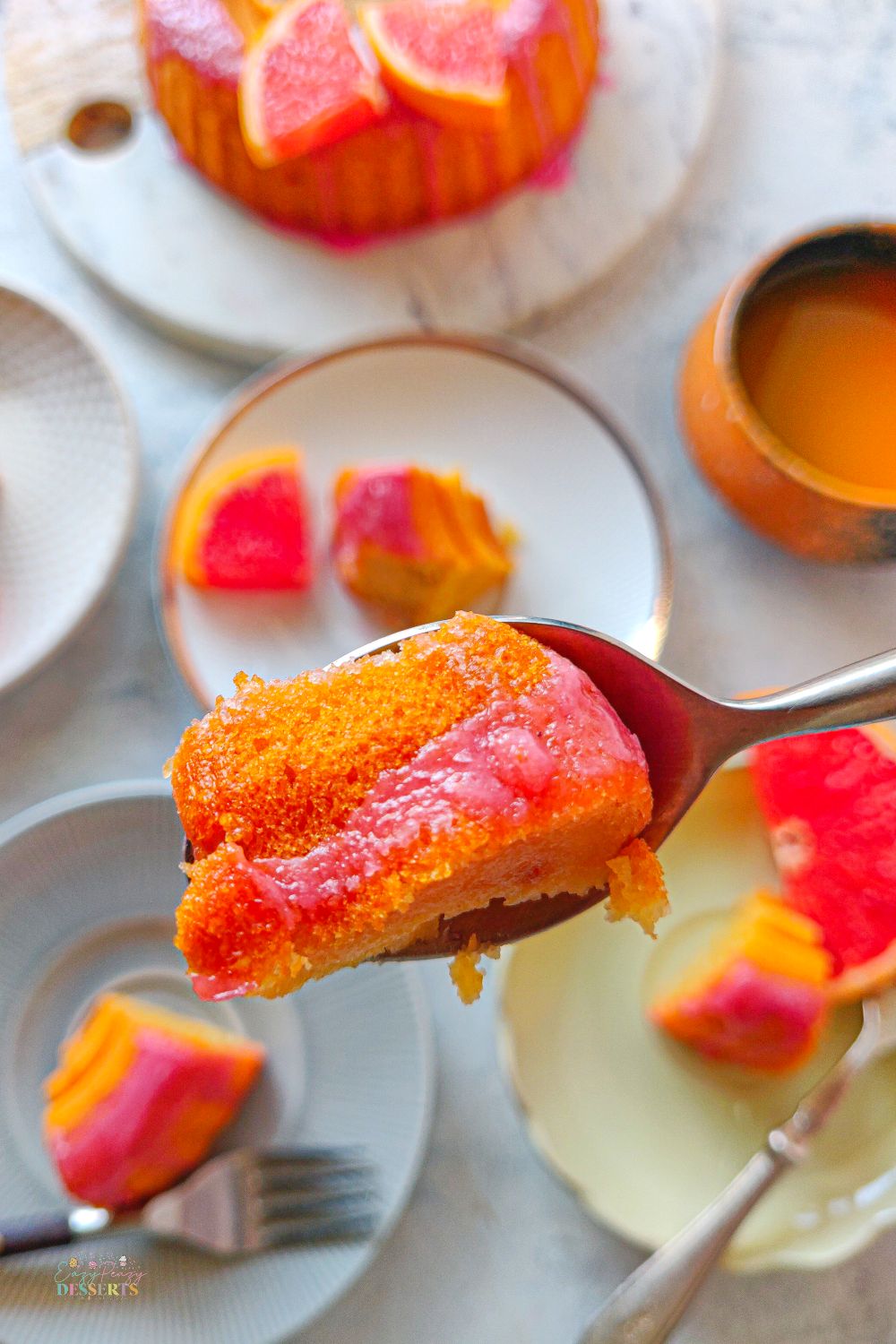 Close up image of a piece of blood orange cake in a dessert spoon