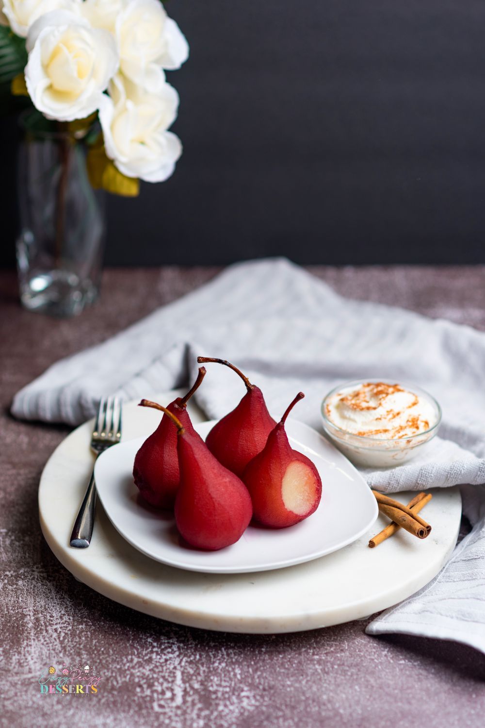 Poached pears in red wine of a white serving plate