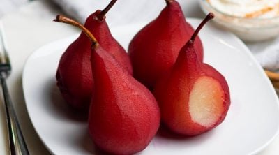 Close up image of wine poached pears on a white serving plate