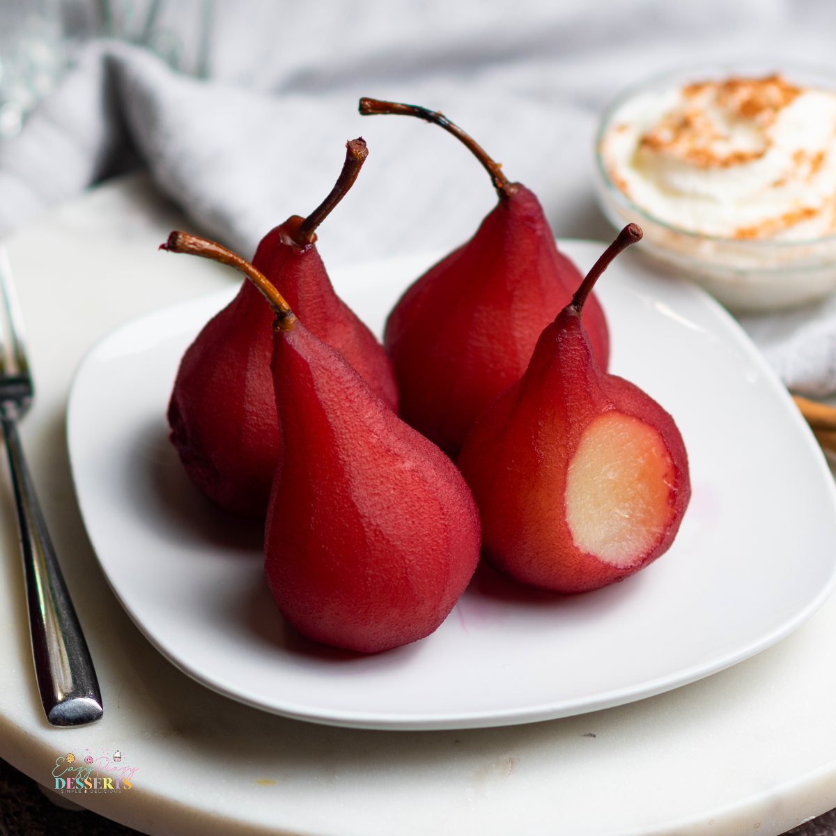 Close up image of wine poached pears on a white serving plate