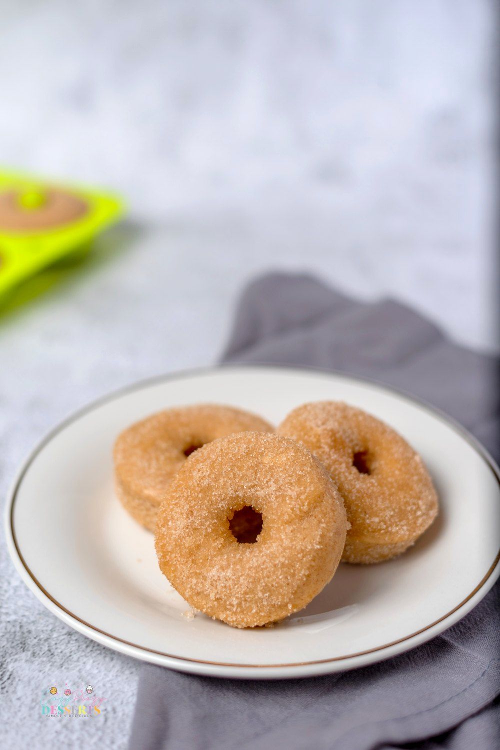 Image of three baked cinnamon donuts on a plate