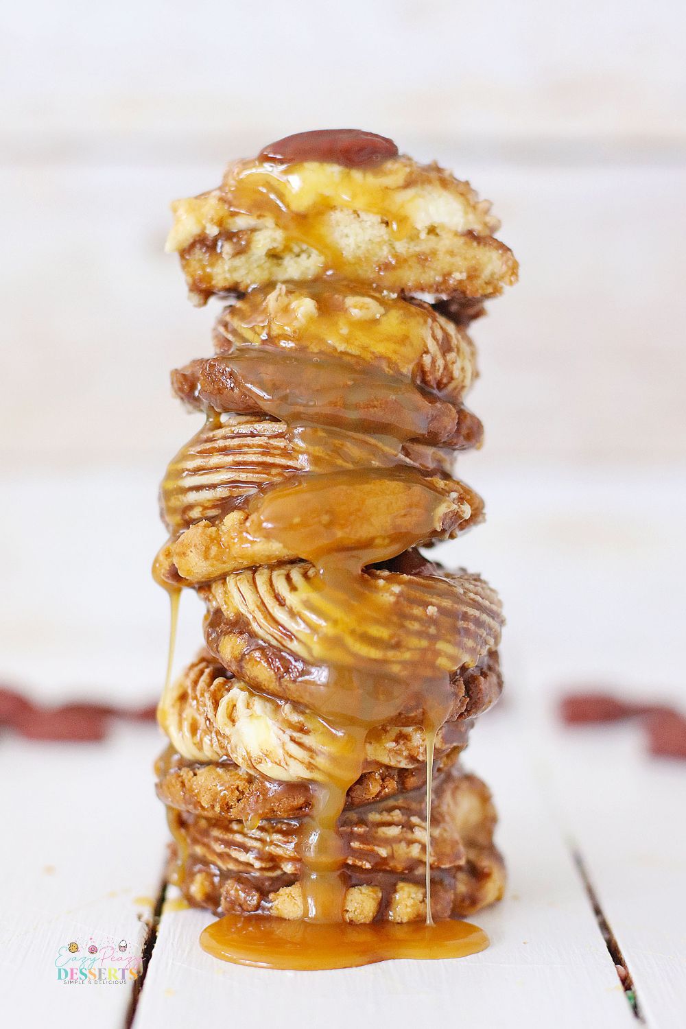 Stack of pecan turtle cookies with caramel sauce