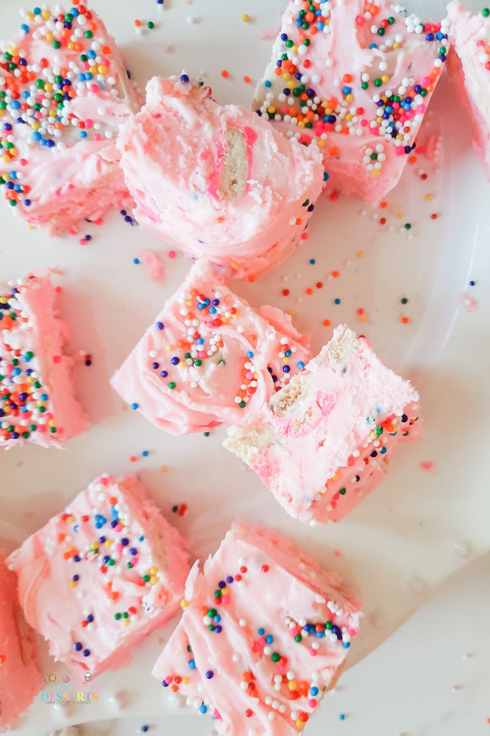 Over head image of a few strawberry fudge bars with sprinkles and cookies