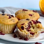 Close up image of orange cranberry muffins on a serving plate