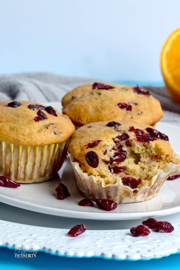 Close up image of orange cranberry muffins on a serving plate