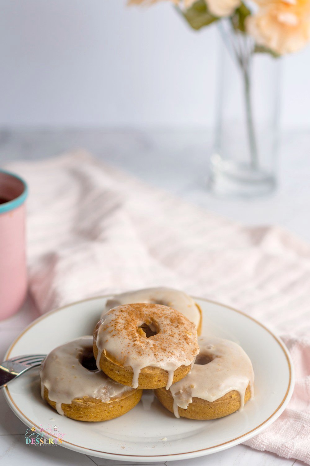 Three maple glazed donuts on a serving plate
