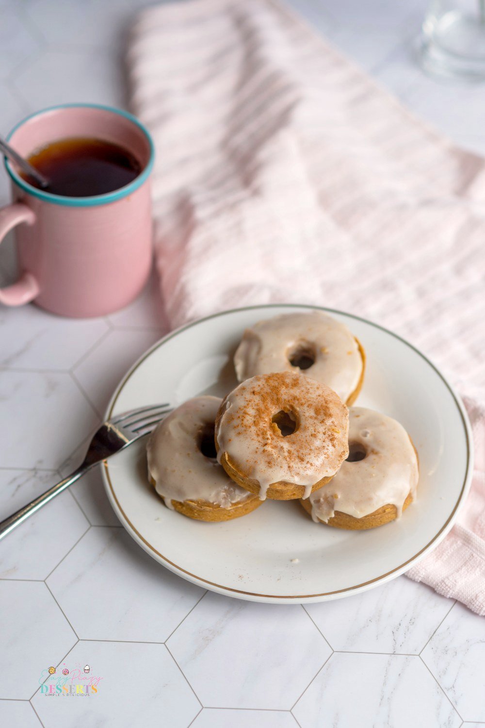 Image of four pumpkin donuts with maple glaze on a serving plate