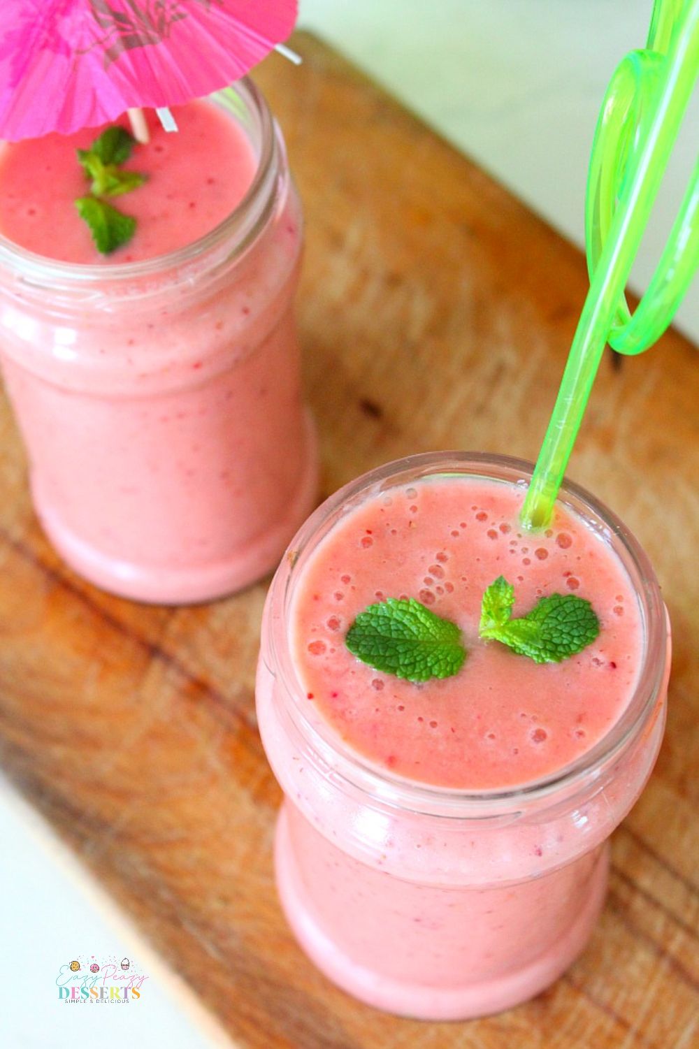 Angled image of jars filled with strawberry protein fruit smoothie